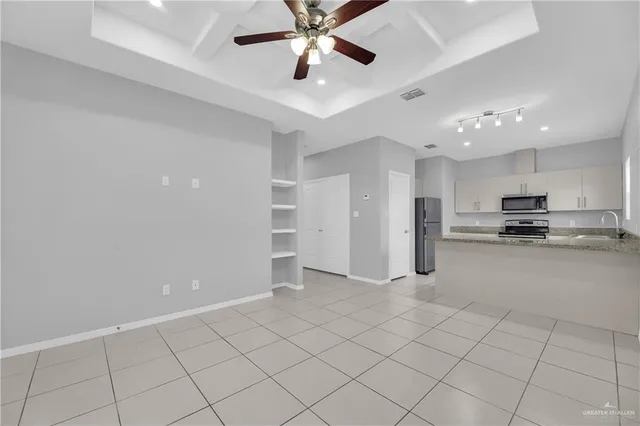 a kitchen with stainless steel appliances granite countertop a sink a stove a microwave and a refrigerator