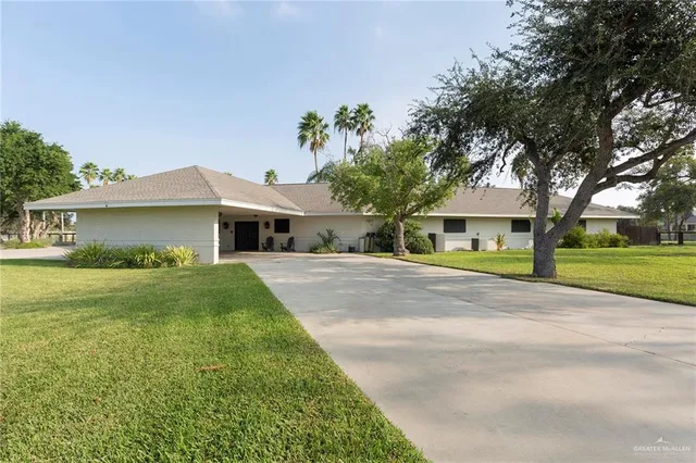 a front view of a house with a yard and trees