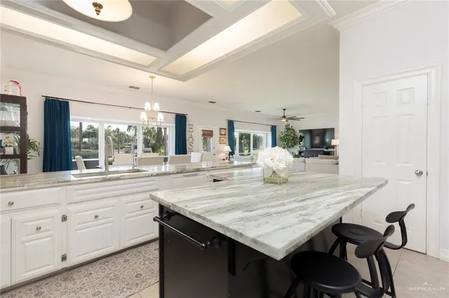 a kitchen with granite countertop a table chairs and wooden floor