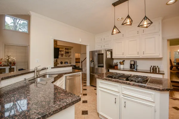 a kitchen with stainless steel appliances granite countertop a sink a stove and cabinets