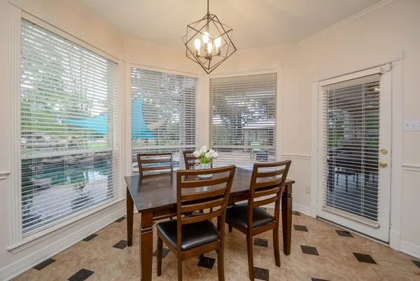 a dining room with furniture a chandelier and wooden floor
