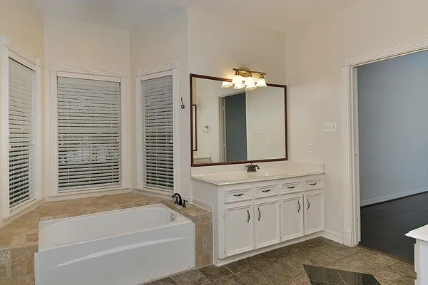 a bathroom with a tub a sink and a window