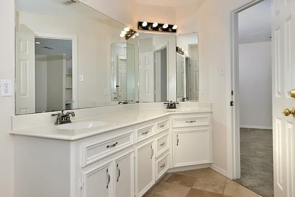 a bathroom with a double vanity sink and a mirror