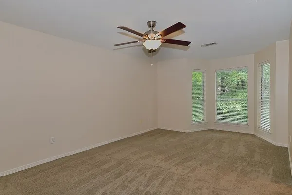 a view of a livingroom with a ceiling fan and window