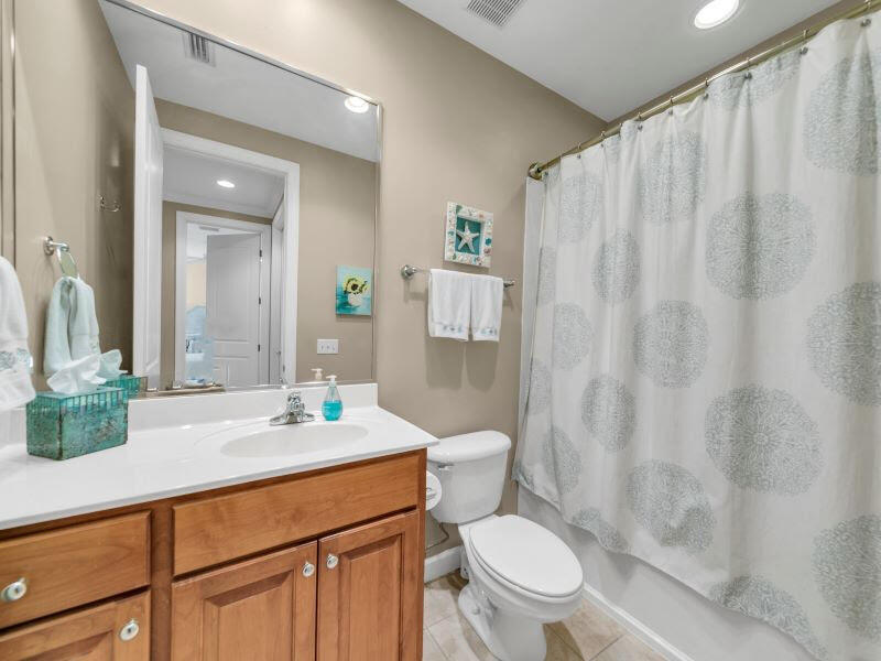 232 South Zander Way Santa Rosa Beach, FL 32459 - Photo 14 of 26 a bathroom with a sink a toilet a mirror and shower curtain