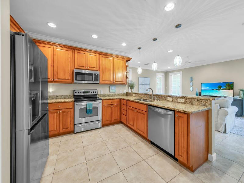 232 South Zander Way Santa Rosa Beach, FL 32459 - Photo 8 of 26 a large kitchen with stainless steel appliances granite countertop a stove top oven a sink and a refrigerator