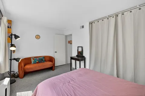a bedroom with bed and a chair