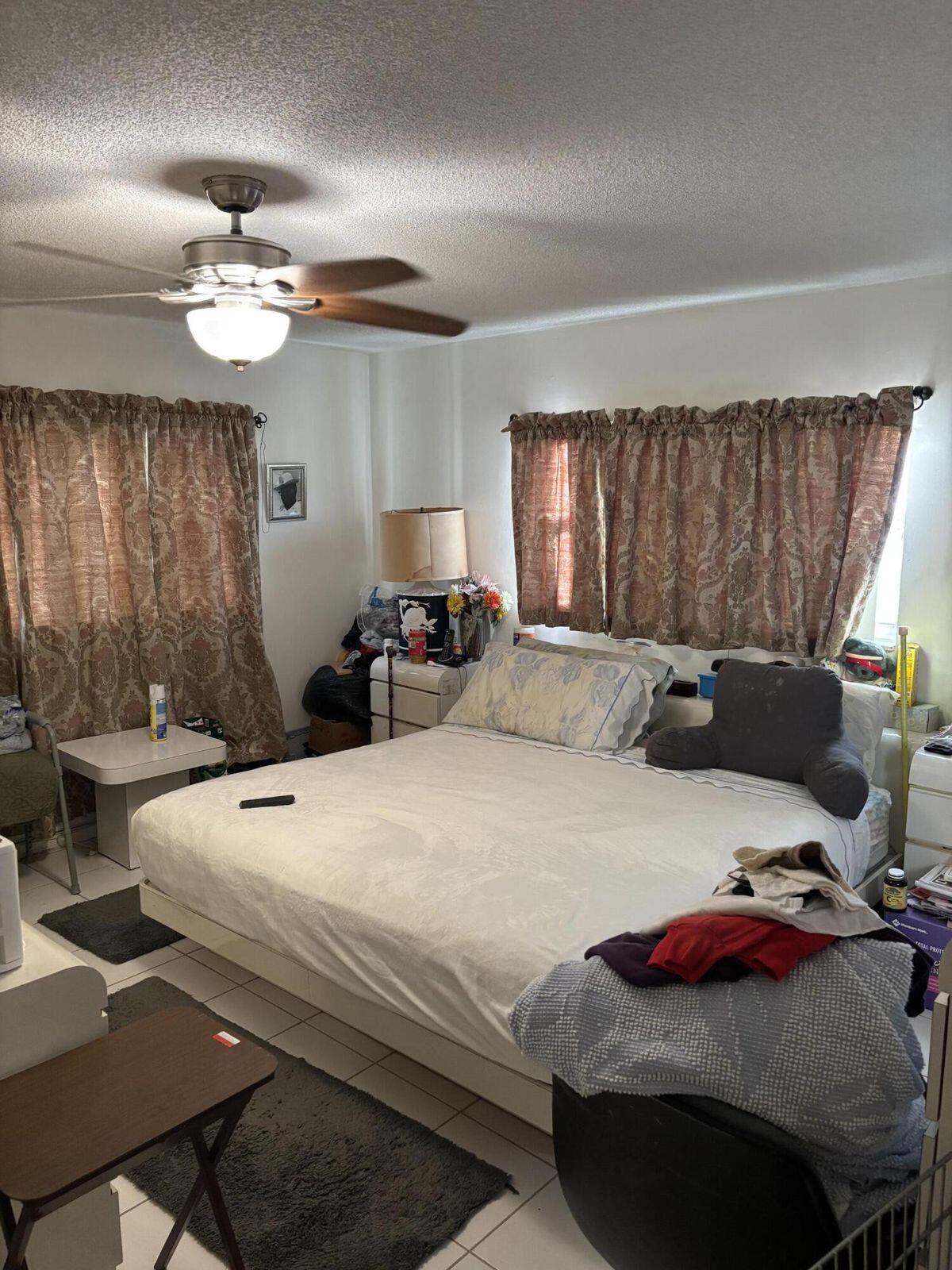 230 Northeast 26th Avenue, Unit 2140 Boynton Beach, FL 33435 - Photo 6 of 9 a bedroom with a bed and a chandelier