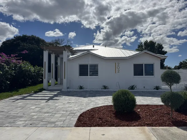 a view of a house with backyard and sitting area