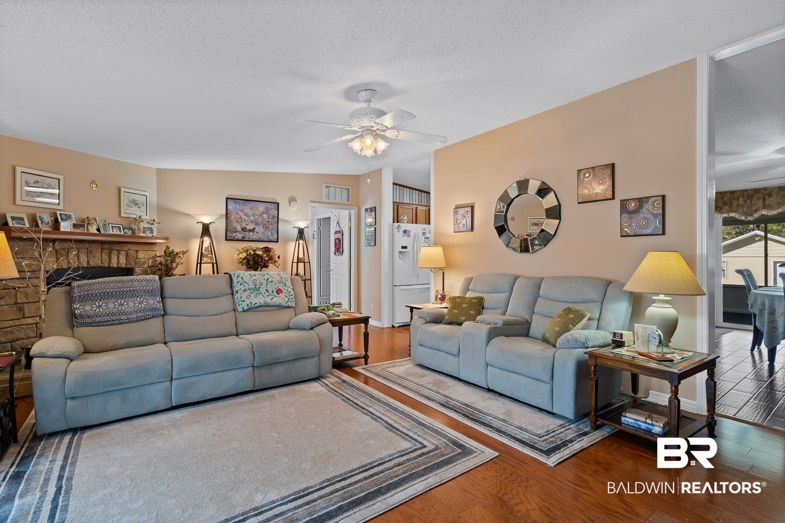 10647 Rte Road Lillian, AL 36549 - Photo 20 of 62 Living room featuring a stone fireplace, ceiling fan, a textured ceiling, and wood finished floors