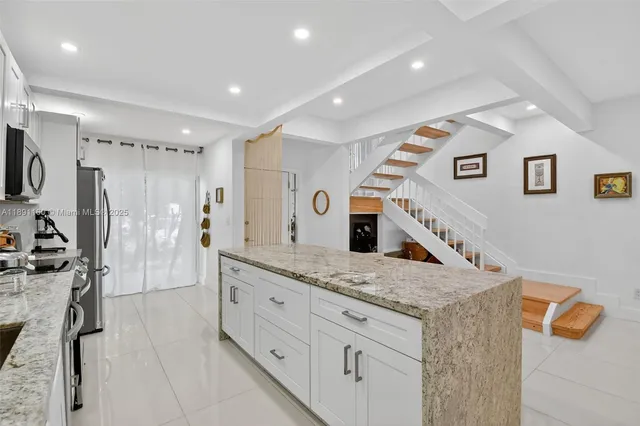 a kitchen with stainless steel appliances granite countertop a sink stove and cabinets