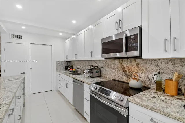 a kitchen with stainless steel appliances granite countertop a refrigerator and a sink