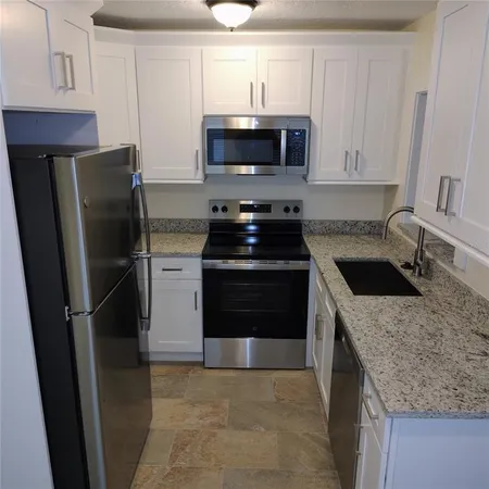 a kitchen with a sink stove and refrigerator