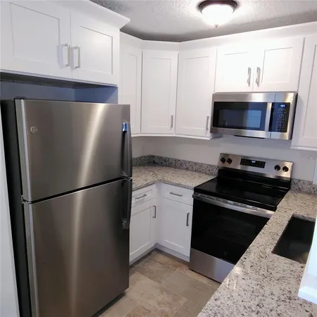 a kitchen with a refrigerator and a stove top oven