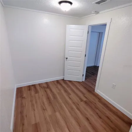 an empty room with wooden floor and closet