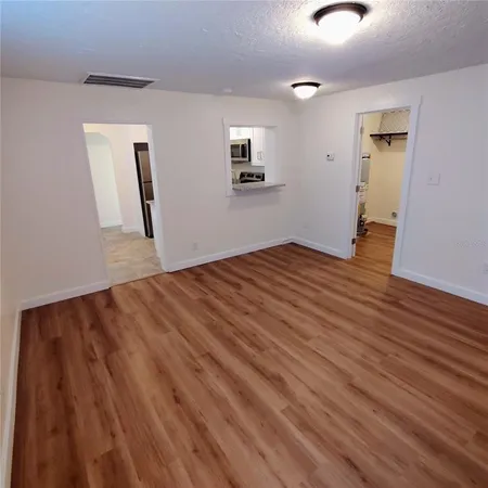 a view of empty room with wooden floor