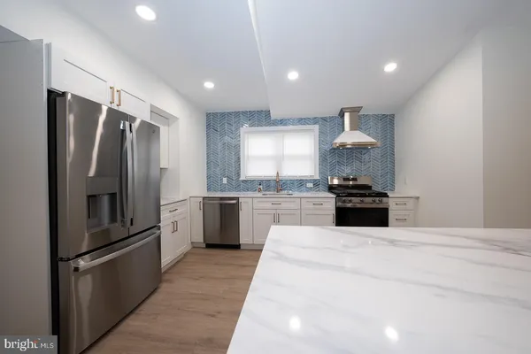 a kitchen with stainless steel appliances granite countertop a refrigerator and a sink