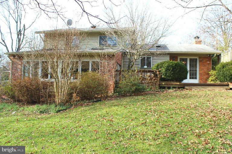 1049 Balls Hill Road McLean, VA 22101 - Photo 2 of 6 a view of a white house next to a yard with large trees