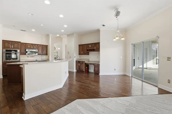 a view of a kitchen with kitchen island a counter top space appliances and cabinets