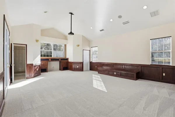 a spacious bedroom with a large bed and a dresser