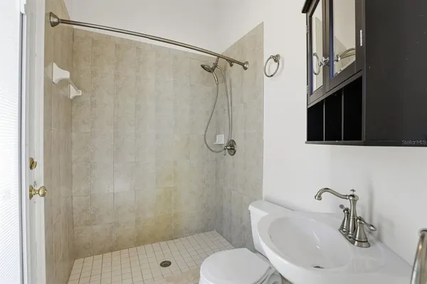 a bathroom with a shower curtain a sink and a toilet