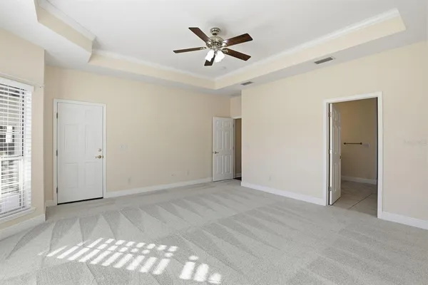 an empty room with fan and windows