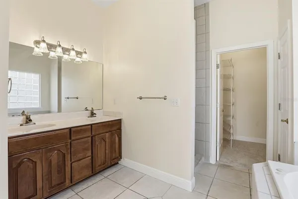 a bathroom with a double vanity sink a mirror and a bathtub