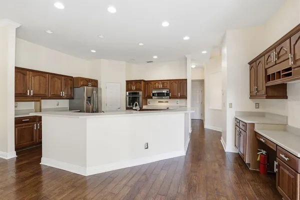 a large kitchen with stainless steel appliances wooden floors and wooden cabinets
