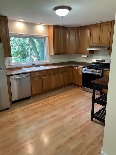 7740 South County Line Road Burr Ridge, IL 60527 - Photo 5 of 13 a kitchen with granite countertop a stove a sink and a microwave