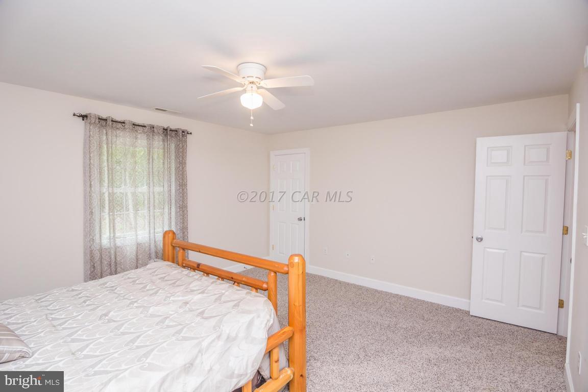 29632 Deal Island Road Princess Anne, MD 21853 - Photo 20 of 33 a bedroom with a bed and a chandelier