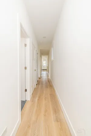 a view of a hallway with wooden floor