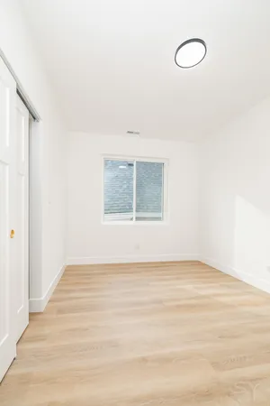a view of a room with wooden floor and window