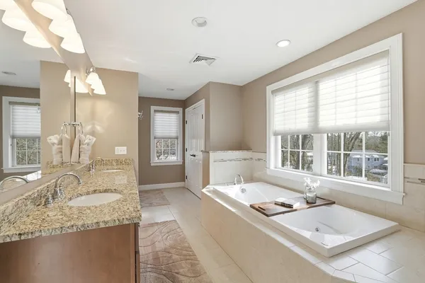 a spacious bathroom with a granite countertop sink and a large mirror