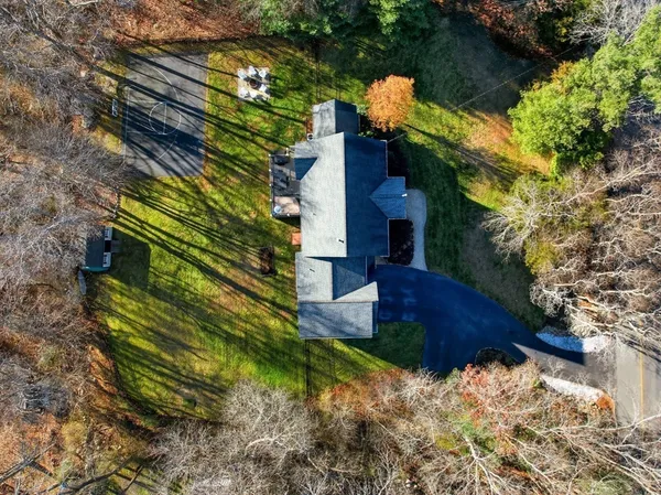 a front view of a house with a yard and trees