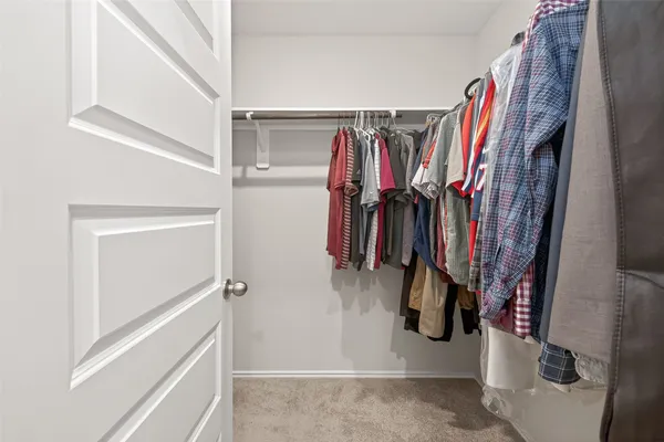 a view of walk in closet with clothes