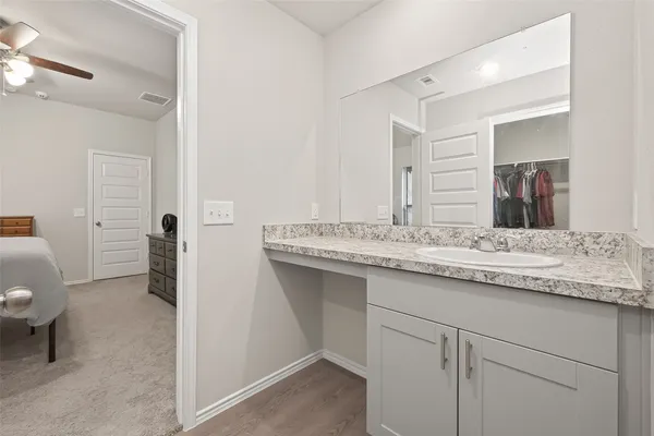 a bathroom with a granite countertop sink and a mirror