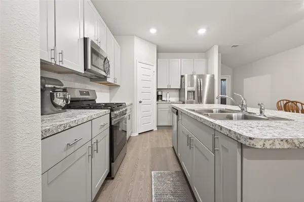 a kitchen with stainless steel appliances granite countertop a sink and cabinets