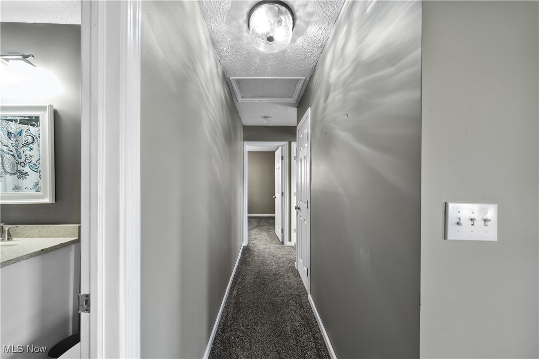 1503 Old Forge Road Kent, OH 44240 - Photo 22 of 38 Hallway with dark colored carpet and a textured ceiling