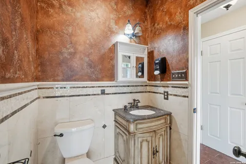 a bathroom with a sink a toilet and a mirror