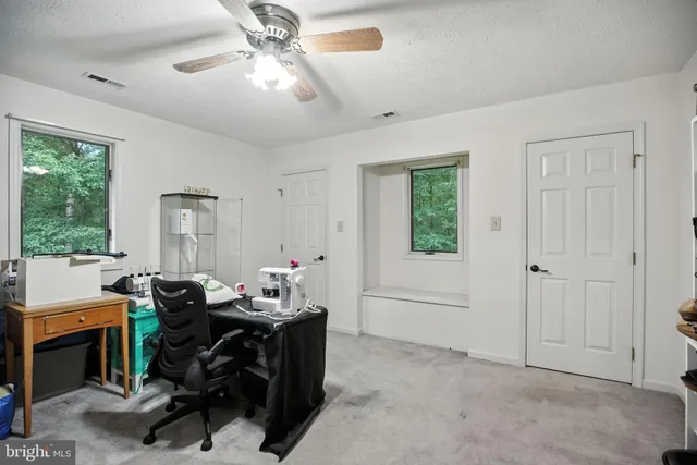 a view of a livingroom with workspace and a window