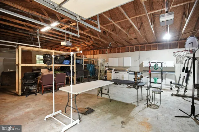 a view of a house with a yard plants and large tree
