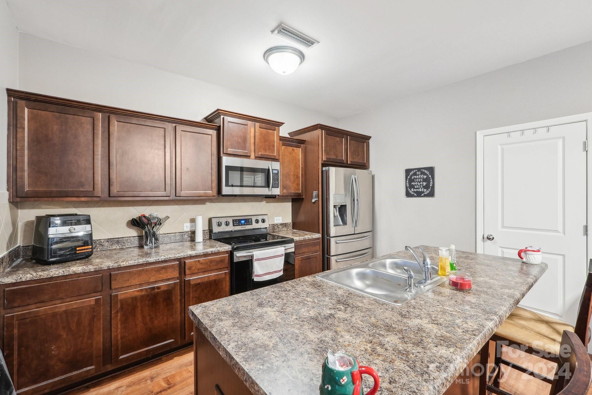 1065 Ramsgate Drive Southwest Concord, NC 28025 - Photo 14 of 47 a kitchen with stainless steel appliances granite countertop a stove top oven a sink dishwasher and cabinets with wooden floor