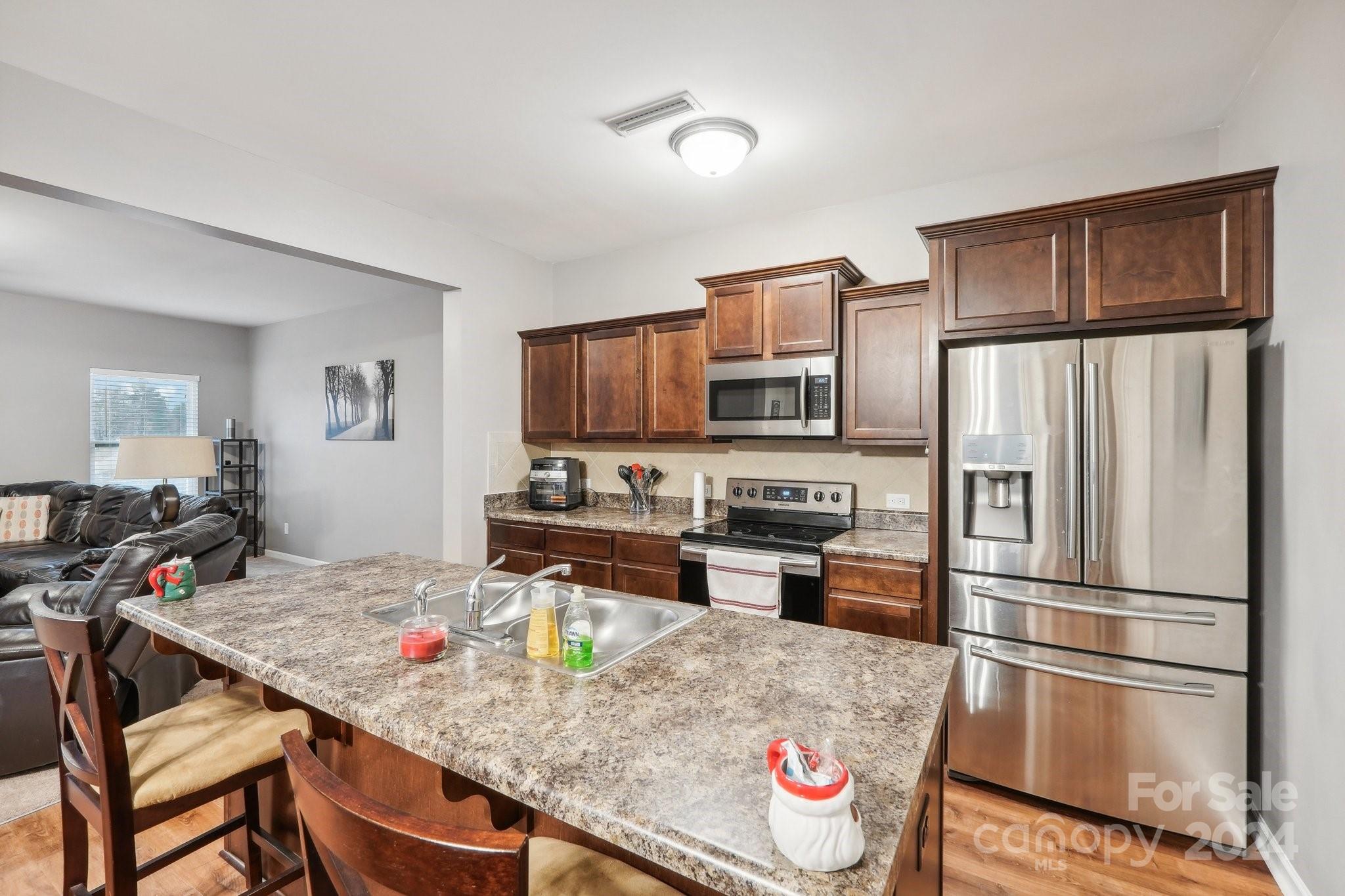 1065 Ramsgate Drive Southwest Concord, NC 28025 - Photo 15 of 47 a kitchen with stainless steel appliances granite countertop a refrigerator stove microwave and sink
