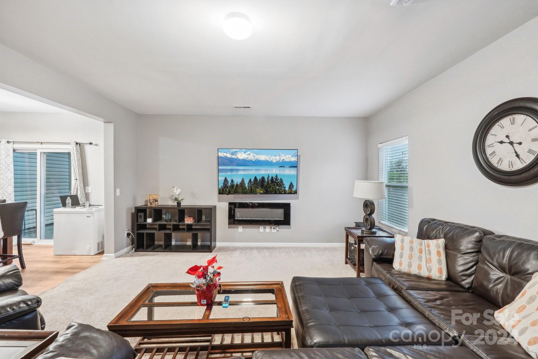 1065 Ramsgate Drive Southwest Concord, NC 28025 - Photo 8 of 47 a living room with furniture a flat screen tv and a wall clock