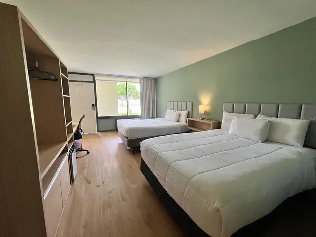 a bedroom with double bed window and a flat tv screen