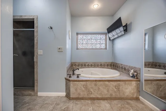 a spacious bathroom with a bathtub and shower