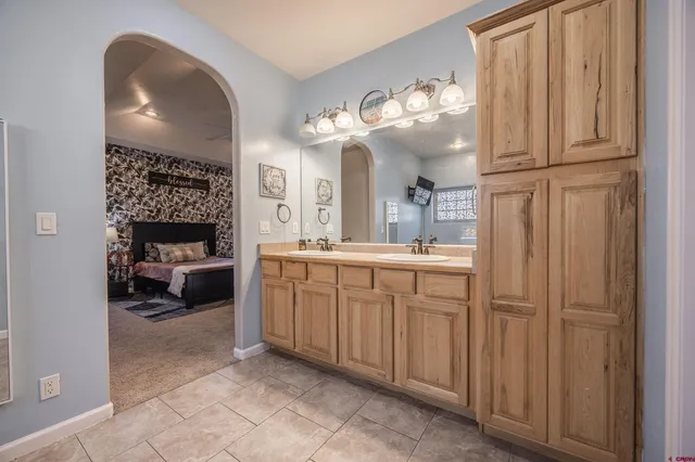 a en suite bathroom with a double vanity sink and a mirror