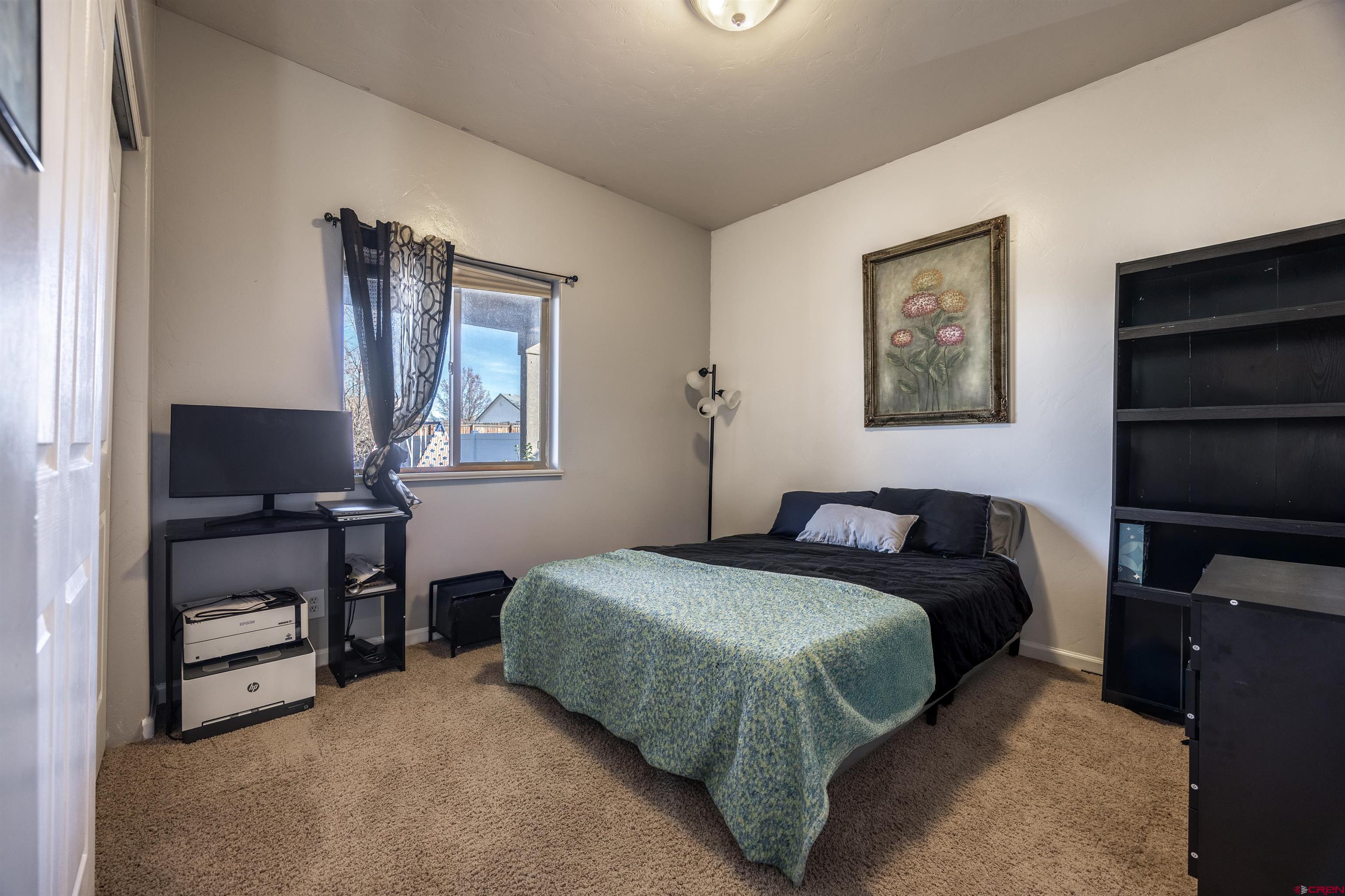 1443 Criterion Street Delta, CO 81416 - Photo 16 of 36 a bedroom with a bed and a flat screen tv