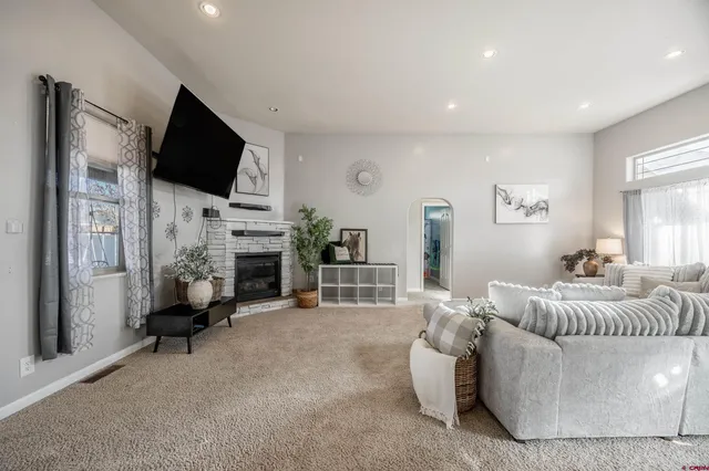 a living room with furniture a fireplace and a flat screen tv