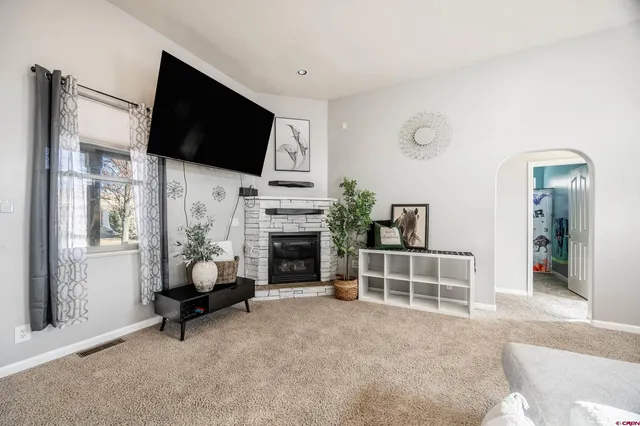 a living room with furniture a flat screen tv and a fireplace